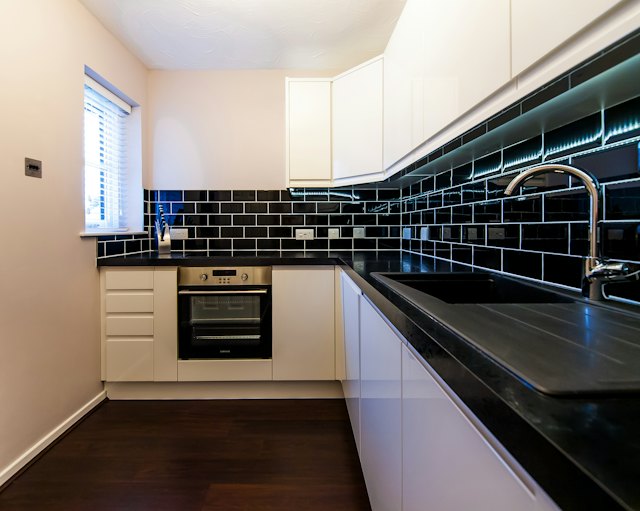 Een keuken met zwarte metrotegels als spatwand boven het werkblad